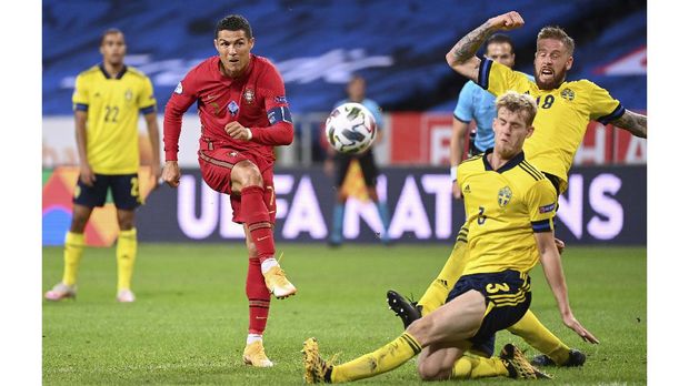 Portugal's forward Cristiano Ronaldo (L) shoots past Sweden's defender Filip Helander (C) and Sweden's defender Pontus Jansson during the UEFA Nations League football match between Sweden and Portugal on September 8, 2020 in Solna, Sweden. (Photo by Jonathan NACKSTRAND / AFP)