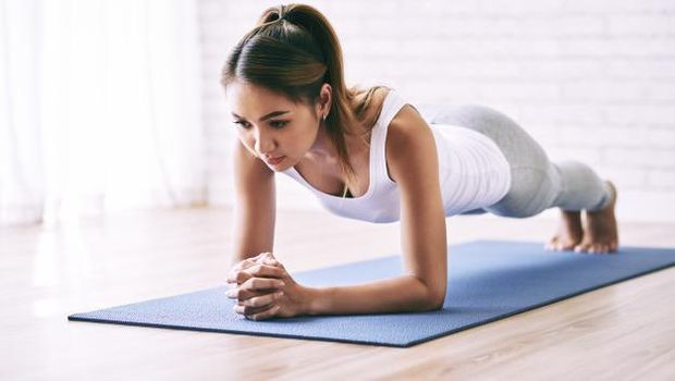 Seorang wanita sedang melakukan forearm plank