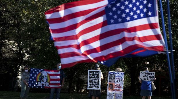 Supporters of Democratic presidential candidate Joe Biden demonstrate as US President Donald Trump visits the Trump National Golf Club on September 5, 2020, in Sterling, Virginia. (Photo by Brendan Smialowski / AFP)