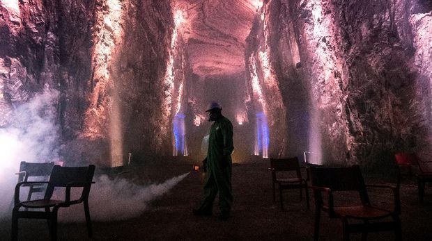 A worker disinfects the Salt Cathedral of Zipaquira, an underground church built into a salt mine, in Zipaquira, 45 km north of Bogota, on August 30, 2020, during the COVID-19 coronavirus pandemic. - The Salt Cathedral, one of Colombia's main touristic attractions, is waiting for an authorization from the Health Ministry for its reopening. (Photo by Juan BARRETO / AFP)