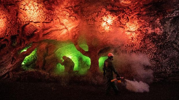 Workers disinfect the Salt Cathedral of Zipaquira, an underground church built into a salt mine, in Zipaquira, 45 km north of Bogota, on August 30, 2020, during the COVID-19 coronavirus pandemic. - The Salt Cathedral, one of Colombia's main touristic attractions, is waiting for an authorization from the Health Ministry for its reopening. (Photo by Juan BARRETO / AFP)