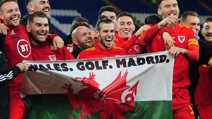 Gareth Bale membentangkan bendera Wales dengan bertuliskan Wales. Golf. Madrid. In That Order.