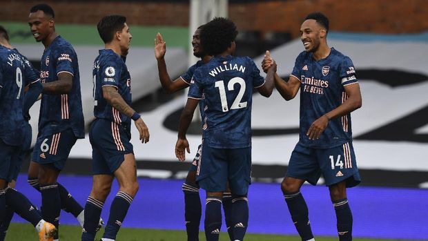 Arsenal's Pierre-Emerick Aubameyang, right, is cheered by teammates after scoring during the English Premier League soccer match between Fulham and Arsenal in London, Saturday, Sept. 12, 2020. (Ben Stansall/Pool via AP)