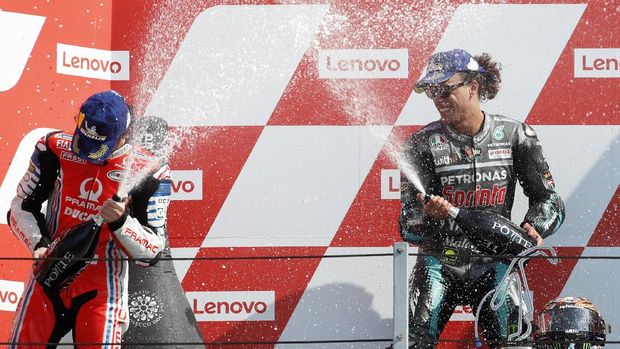 Second placed Francesco Bagnaia, left, and winner Franco Morbidelli, both of Italy, spray each other on the podium of the MotoGP race of the San Marino Motorcycle Grand Prix at the Misano circuit in Misano Adriatico, Italy, Sunday, Sept. 13, 2020. (AP Photo/Antonio Calanni)