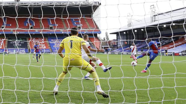 Crystal Palace's Wilfried Zaha, right, scores his side's opening goal during the English Premier League soccer match between Crystal Palace and Southampton, at Selhurst Park, London, Saturday, Sept. 12, 2020. (Richard Heathcote, Pool via AP)