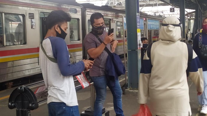 Penumpang KRL di Stasiun Tanah Abang masih menggunakan masker scuba dan masker buff