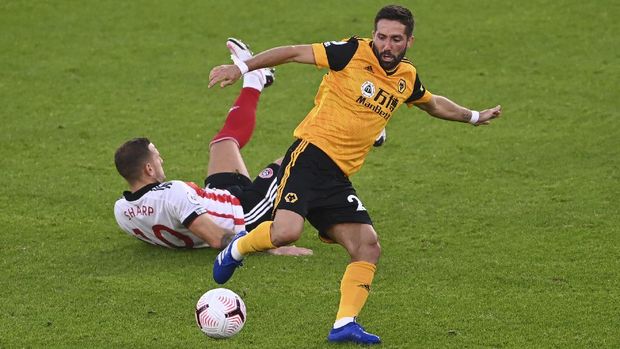Sheffield United's Billy Sharp falls after competing for the ball with Wolverhampton Wanderers' Joao Moutinho during the English League Cup soccer match between Sheffield United and Wolves at Bramall Lane stadium in Sheffield, England, Monday, Sept. 14, 2020. (Laurence Griffiths/Pool via AP)