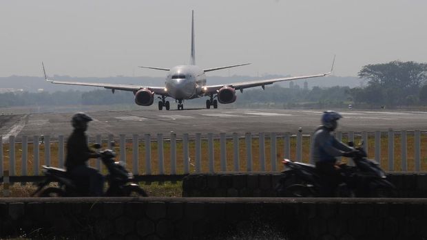 Sejumlah pengendara motor melintas dengan latar belakang pesawat komersial yang akan lepas landas di Bandara Adi Soemarmo, Boyolali, Jawa Tengah, Rabu (16/9/2020). Berdasarkan data PT Angkasa Pura I Bandara Adi Soemarmo, pengguna jasa penerbangan saat pandemi COVID-19 melalui bandara tersebut mulai naik dari bulan Mei sebanyak 17 ribu penumpang naik menjadi 34 ribu penumpang pada bulan Agustus. ANTARA FOTO/Aloysius Jarot Nugroho/aww.