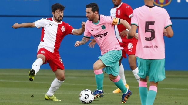 Barcelona's Lionel Messi, center, vies for the ball with Girona's Jairo Izquierdo during the pre-season friendly soccer match between Barcelona and Girona at the Johan Cruyff Stadium in Barcelona, Spain, Wednesday, Sept. 16, 2020. (AP Photo/Joan Monfort)