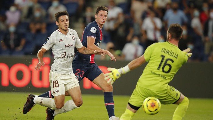 Metzs goalkeeper Alexandre Oukidja, right, makes a save against PSGs Julian Draxler, center, during the French League One soccer match between Paris Saint-Germain and Metz at the Parc des Princes in Paris, France, Wednesday, Sept.16, 2020. (AP Photo/Francois Mori)