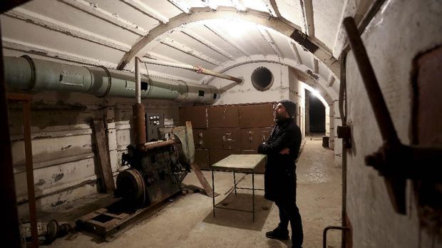 In this photograph taken on February 2, 2020, museum guide Besian Dida, stands in the ventilation room of The Cold War Tunnel Museum in Gjirokastra, Albania. - Snaking beneath a fortress in southern Albania, a covert tunnel network built during the country's communist era captures the secrecy and paranoia that defined the long rule of former tyrant Enver Hoxha.Today communism is gone and the military bunker is a tourist attraction, still drawing rare visitors during the pandemic, when themes of fear, isolation and confinement are particularly resonant. The sprawling underground complex, now dubbed the Cold War tunnel, is part of a vast and costly 