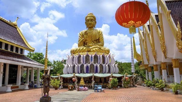 A giant Buddha statue is pictured at the Buddhist temple Wat Samphran (Dragon Temple) in Nakhon Pathom, some 40km west of Bangkok, on September 11, 2020. - Wat Samphran is a popular tourist destination with visitors coming to see the huge dragon figure curling around a pink cylindrical building next to the Buddha statues and places of worship of the traditional Buddhist temple complex. (Photo by Mladen ANTONOV / AFP)