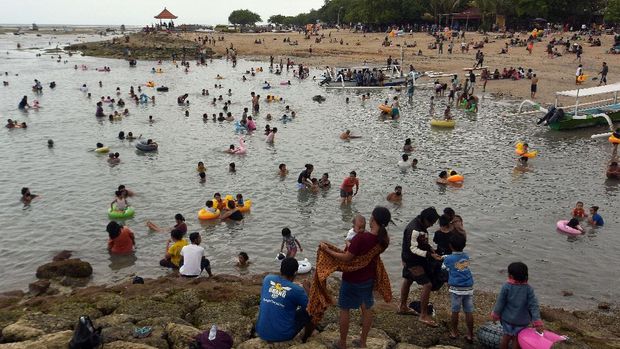 Warga membludak saat liburan Hari Raya Galungan di Pantai Sanur, Denpasar, Bali, Kamis (17/9/2020). Objek wisata tersebut masih dibuka meskipun sejumlah ruang publik di Denpasar ditutup menyusul terus melonjaknya kasus penularan COVID-19 di daerah itu. ANTARA FOTO/Nyoman Hendra Wibowo/aww.