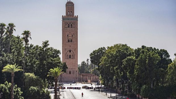 A few people walk by next to the Kutubiyya mosque's minaret tower at the Jemaa el-Fna square in the Moroccan city of Marrakesh on September 8, 2020, currently empty of its usual crowds due to the COVID-19 pandemic. - Snake charmers, storytellers and crowds of tourists; the legendary Jamaa El Fna square of Morocco's Marrakech is almost as famous for the number of visitors as its colourful performers. But with tough government restrictions imposed to stem the spread of the novel coronavirus, the tourism industry on which Marrakech depends screeched to a halt. (Photo by FADEL SENNA / AFP)