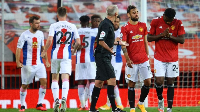 MANCHESTER, ENGLAND - SEPTEMBER 19: Referee Martin Atkinson speaks with Bruno Fernandes and Tim Fosu-Mensah of Manchester United after Manchester United concede a second goal during the Premier League match between Manchester United and Crystal Palace at Old Trafford on September 19, 2020 in Manchester, England. (Photo by Richard Heathcote/Getty Images )