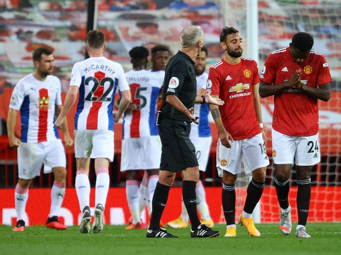MANCHESTER, ENGLAND - SEPTEMBER 19: Referee Martin Atkinson speaks with Bruno Fernandes and Tim Fosu-Mensah of Manchester United after Manchester United concede a second goal during the Premier League match between Manchester United and Crystal Palace at Old Trafford on September 19, 2020 in Manchester, England. (Photo by Richard Heathcote/Getty Images )