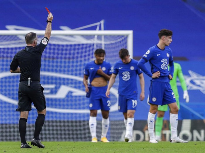 Referee Paul Tierney shows a red card to Chelsea's Andreas Christensen, not pictured, during the English Premier League soccer match between Chelsea and Liverpool at Stamford Bridge Stadium, Sunday, Sept. 20, 2020. (AP Photo/Matt Dunham, Pool)