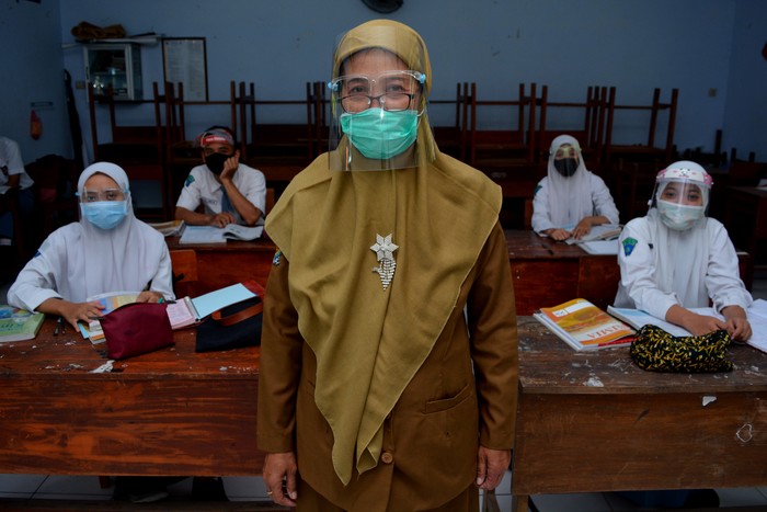 Seorang guru sekolah dasar mengajar pelajaran agama di rumah muridnya di Kelurahan Pesantren, Kota Kediri, Jawa Timur, Selasa (15/9/2020). Pembelajaran kelompok kecil di rumah siswa sekali dalam sebulan tersebut sebagai evaluasi penguasan materi pelajaran sekaligus upaya penyegaran agar siswa tidak bosan mengikuti pembelajaran jarak jauh.