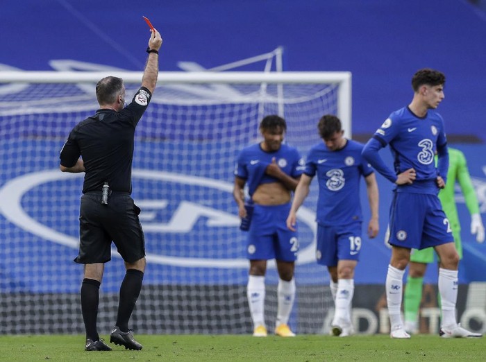 Referee Paul Tierney shows a red card to Chelseas Andreas Christensen, not pictured, during the English Premier League soccer match between Chelsea and Liverpool at Stamford Bridge Stadium, Sunday, Sept. 20, 2020. (AP Photo/Matt Dunham, Pool)