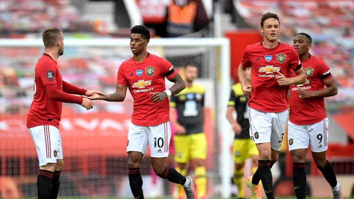 MANCHESTER, ENGLAND - JULY 13: Marcus Rashford of Manchester United celebrates with teammate Luke Shaw of Manchester United after scoring his teams first goal during the Premier League match between Manchester United and Southampton FC at Old Trafford on July 13, 2020 in Manchester, England. Football Stadiums around Europe remain empty due to the Coronavirus Pandemic as Government social distancing laws prohibit fans inside venues resulting in all fixtures being played behind closed doors. (Photo by Peter Powell/Pool via Getty Images)
