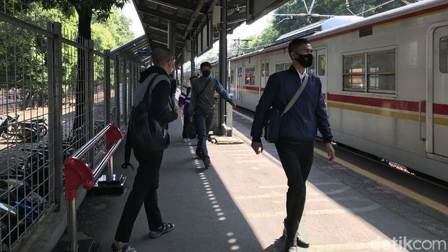 Penumpang KRL yang masih menggunakan masker scuba-buff di Stasiun Kalibata