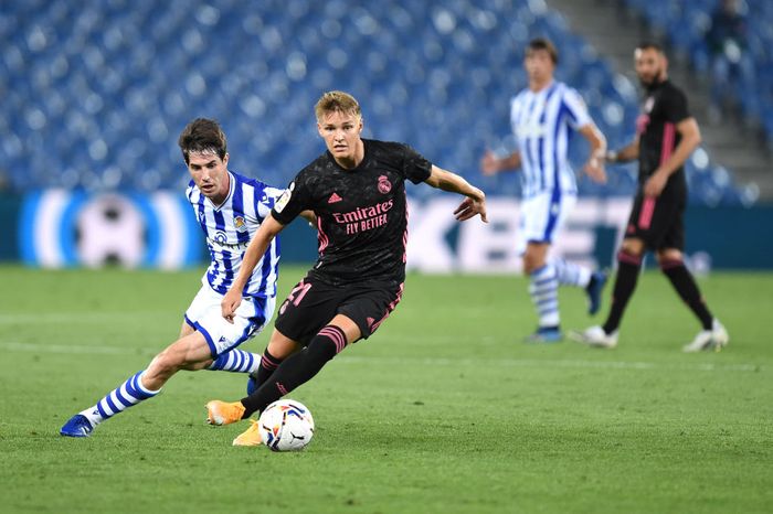 Real Madrid SAN SEBASTIAN, SPAIN - SEPTEMBER 20: Martin Oedegaard of Real Madrid battles for possession with Aritz Elustondo of Real Sociedad during the La Liga Santander match between Real Sociedad and Real Madrid at Estadio Anoeta on September 20, 2020 in San Sebastian, Spain. (Photo by Juan Manuel Serrano Arce/Getty Images)