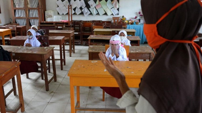 PEMBELAJARAN TATAP MUKA SD DI ACEH Guru mengajar anak berdoa pada hari pertama proses belajar mengajar di Sekolah Dasar Negeri Garot, Desa Ketapang, Kecamatan Darui Imarah, Kabapaten Aceh Besar, Aceh, Rabu (23/9/2020). Sebagian sekolah di daerah itu mulai melaksanakan aktivitas belajar mengajar tatap muka dengan membatasi jumlah murid dan tetap menerapkan protokol kesehatan guna mencegah penyebaran COVID-19. ANTARA FOTO/Ampelsa/aww.
