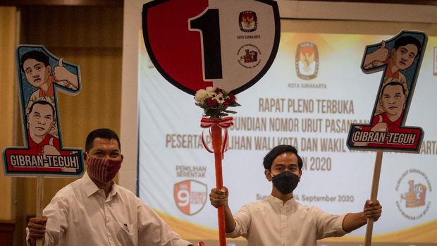 Pasangan Calon Wali Kota dan Wakil Wali Kota Solo dari Partai PDI Perjuangan, Gibran Rakabuming Raka (kanan) dan Teguh Prakosa (kiri) menunjukan poster nomor urut satu usai acara Rapat Pleno Komisi Pemilihan Umum (KPU) Pengundian Nomor Urut Peserta Pemilihan Wali Kota dan Wakil Wali Kota Solo di Hotel Sunan, Solo, Jawa Tengah, Kamis (24/9/2020). Berdasarkan pengundian nomor urut pemilihan Wali Kota dan Wakil Wali Kota Solo pada Pilkada 2020 Desember mendatang, pasangan Gibran Rakabuming Raka dan Teguh Prakosa mendapat nomor urut satu sedangkan lawannya pasangan Bagyo Wahyono dan FX. Supardjo mendapatkan nomor urut dua. ANTARA FOTO/Mohammad Ayudha.