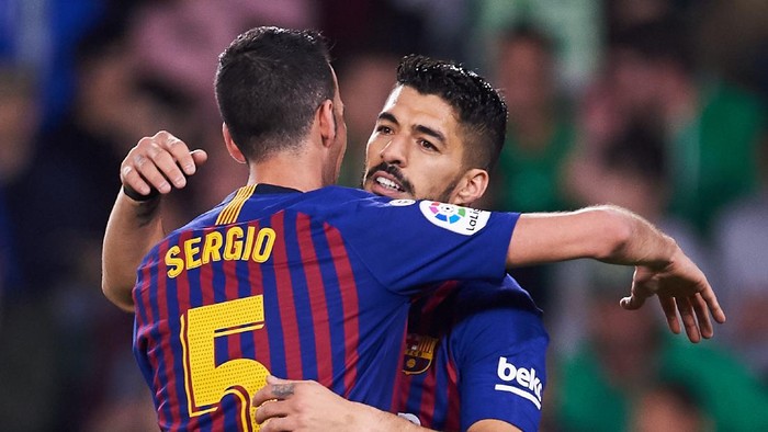 SEVILLE, SPAIN - MARCH 17: Luis Suarez of FC Barcelona celebrates with his teammates Sergio Busquets of FC Barcelona after scoring his teams third goal during the La Liga match between Real Betis Balompie and FC Barcelona at Estadio Benito Villamarin on March 17, 2019 in Seville, Spain. (Photo by Aitor Alcalde/Getty Images)