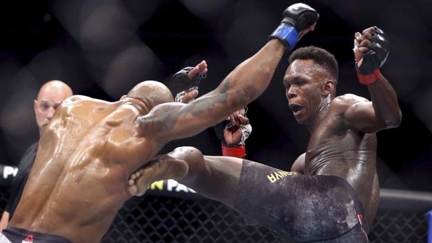 FILE- In this March 7, 2020, file photo, UFC middleweight champion Israel Adesanya, right, of Nigeria, kicks challenger Yoel Romero, of Cuba, during the second round of their UFC 248 fight at the T-Mobile Arena in Las Vegas. Israel Adesanya returns to the UFC cage this weekend to defend his middleweight title against Paulo Costa in the main event of UFC 253. (L.E. Baskow/Las Vegas Review-Journal via AP, File)