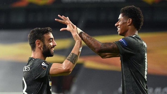 COLOGNE, GERMANY - AUGUST 16: Bruno Fernandes of Manchester United  celebrates with Marcus Rashford  after scoring his teams first goal from the penalty spot during the UEFA Europa League Semi Final between Sevilla and Manchester United at RheinEnergieStadion on August 16, 2020 in Cologne, Germany. (Photo by Ina Fassbender/Pool via Getty Images)