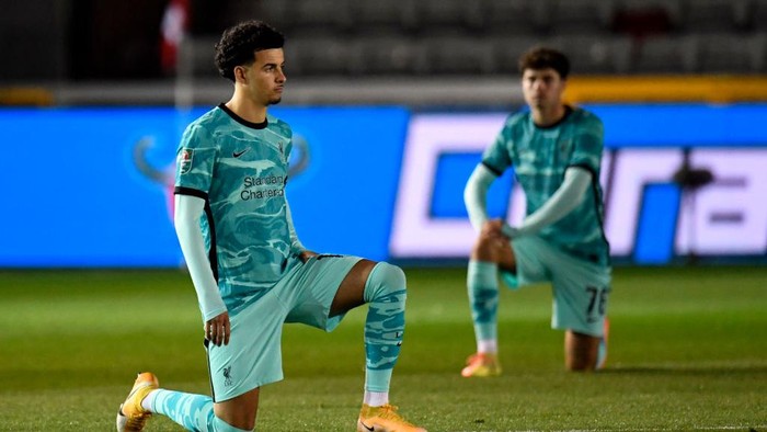 LINCOLN, ENGLAND - SEPTEMBER 24:  Curtis Jones of Liverpool takes a knee in support of the Black Lives Matter Movement prior to prior to the Carabao Cup third round match between Lincoln City and Liverpool at Sincil Bank Stadium on September 24, 2020 in Lincoln, England. Football Stadiums around United Kingdom remain empty due to the Coronavirus Pandemic as Government social distancing laws prohibit fans inside venues resulting in fixtures being played behind closed doors. (Photo by Peter Powell -