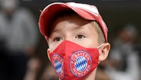 Bahkan ada anak kecil juga yang menyaksikan pertandingan, yakni suporter Bayern Munich, yang terlihat dari maskernya. (Foto: Tibor Ilyes - Pool/Getty Images)