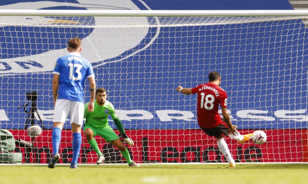 Manchester United's Bruno Fernandes, right shoots and scores his sides third goal from the penalty spot during the English Premier League soccer match between Brighton Hove Albion and Manchester United in Brighton, England, Saturday, Sept. 26, 2020. (John Sibley/Pool via AP)