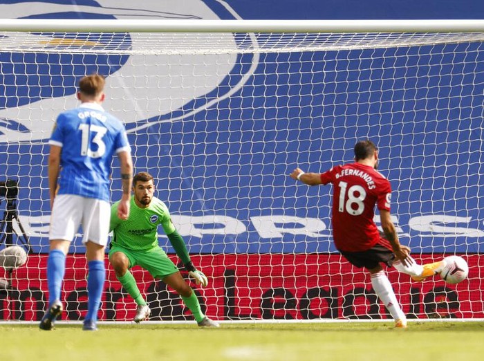 Manchester United's Bruno Fernandes, right shoots and scores his sides third goal from the penalty spot during the English Premier League soccer match between Brighton Hove Albion and Manchester United in Brighton, England, Saturday, Sept. 26, 2020. (John Sibley/Pool via AP)