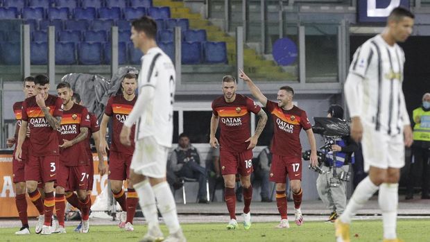 Roma's Jordan Veretout, right, celebrates after scoring his side's second goal during the Italian Serie A soccer match between Roma and Juventus at Rome's Olympic stadium, Sunday, Sept. 27, 2020. (AP Photo/Gregorio Borgia)