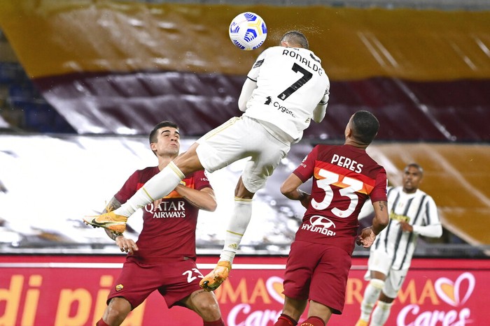 Cristiano Ronaldo Juventus' Cristiano Ronaldo, center, jumps for the ball to score during the Italian Serie A soccer match between Roma and Juventus at Rome's Olympic stadium, Sunday, Sept. 27, 2020. (Fabio Rossi/LaPresse via AP)
