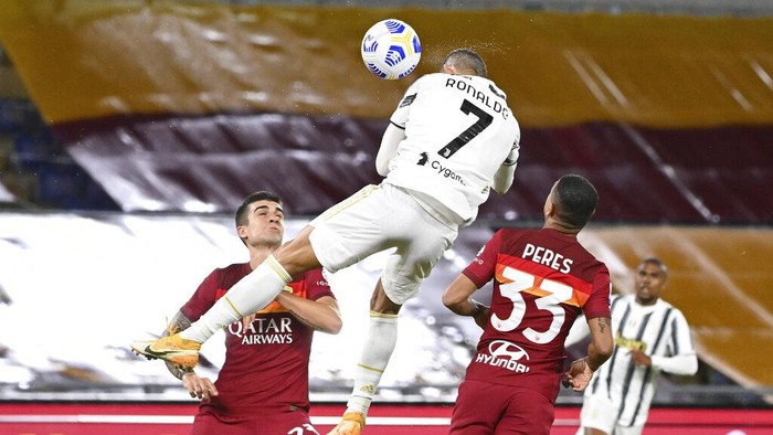 Juventus Cristiano Ronaldo, center, jumps for the ball to score during the Italian Serie A soccer match between Roma and Juventus at Romes Olympic stadium, Sunday, Sept. 27, 2020. (Fabio Rossi/LaPresse via AP)