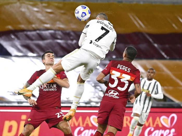 Juventus' Cristiano Ronaldo, center, jumps for the ball to score during the Italian Serie A soccer match between Roma and Juventus at Rome's Olympic stadium, Sunday, Sept. 27, 2020. (Fabio Rossi/LaPresse via AP)