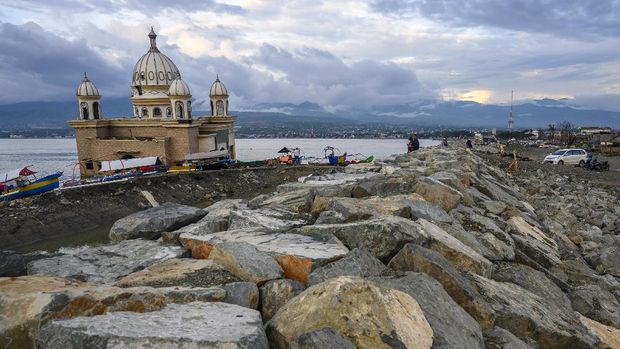 Warga menikmati pemandangan di dekat masjid terapung yang amblas ke laut akibat diterjang tsunami di pantai Kampung Lere, Palu, Sulawesi Tengah, Minggu (27/9/2020). Setelah dua tahun bencana gempa, tsunami, dan likuefaksi di Palu, Sigi dan Donggala 28 September 2018 yang menelan korban lebih dari 5.000 jiwa, garis pantai di masjid yang telah dijadikan dijadikan 