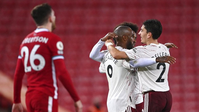 Arsenals Alexandre Lacazette, centre, is congratulated by teammates after scoring his teams first goal during the English Premier League soccer match between Liverpool and Arsenal at Anfield in Liverpool, England, Monday, Sept. 28, 2020. (Laurence Griffiths/Pool via AP)