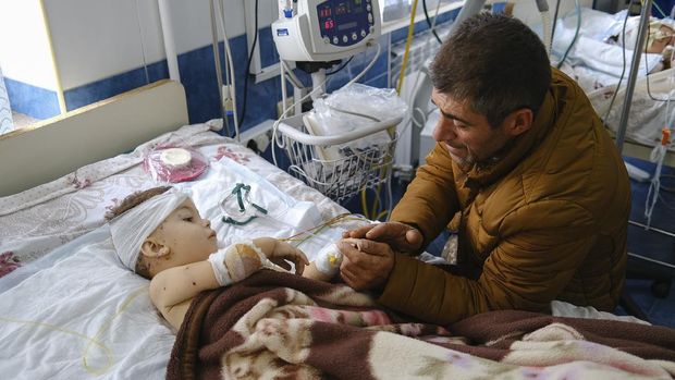 A man speaks with his child, wounded during shelling, in Stepanakert, the self-proclaimed Republic of Nagorno-Karabakh, Azerbaijan, Monday, Sept. 28, 2020. Fighting between Armenian and Azerbaijani forces over the disputed separatist region of Nagorno-Karabakh continued on Monday morning after erupting the day before, with both sides blaming each other for resuming the attacks. (Areg Balayan/PAN Photo via AP)