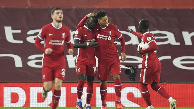 Liverpool's Sadio Mane, second lefties congratulated by teammates after scoring his team's first goal during the English Premier League soccer match between Liverpool and Arsenal at Anfield in Liverpool, England, Monday, Sept. 28, 2020. (Paul Ellis/Pool via AP)