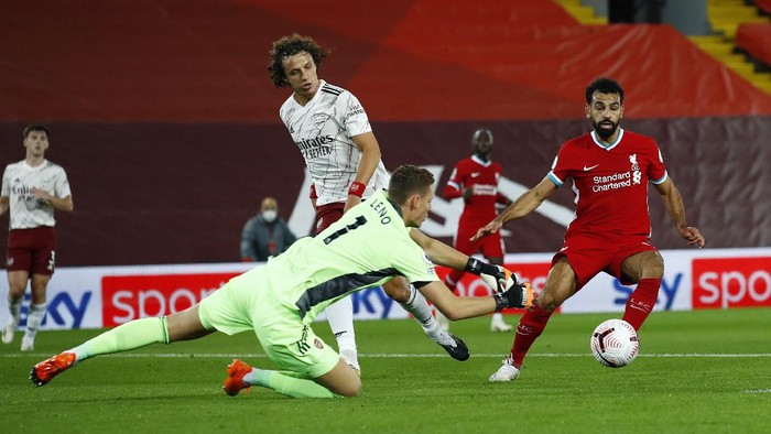 LIVERPOOL, ENGLAND - SEPTEMBER 28: Bernd Leno of Arsenal dives for the ball ahead of Mohamed Salah of Liverpool during the Premier League match between Liverpool and Arsenal at Anfield on September 28, 2020 in Liverpool, England. Sporting stadiums around the UK remain under strict restrictions due to the Coronavirus Pandemic as Government social distancing laws prohibit fans inside venues resulting in games being played behind closed doors. (Photo by Jason Cairnduff - Pool/Getty Images)