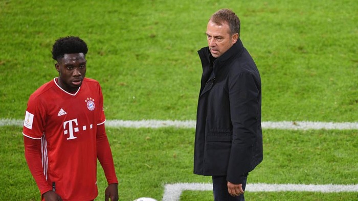 MUNICH, GERMANY - SEPTEMBER 30: Bayern Munichs Alphonso Davies and coach Hansi Flick during the Supercup 2020 match between FC Bayern München and Borussia Dortmund at Allianz Arena on September 30, 2020 in Munich, Germany. (Photo by Andreas Gebert - Pool/Getty Images )