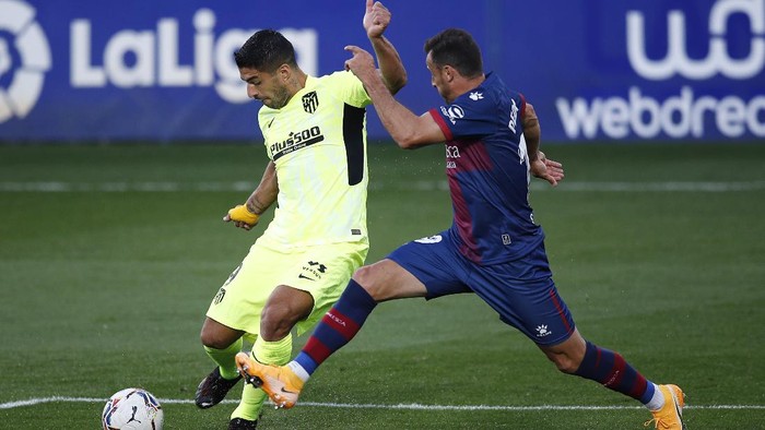 HUESCA, SPAIN - SEPTEMBER 30: Luis Suarez of Atletico de Madrid shoots under pressure from Pedro Lopez of SD Huesca during the La Liga Santander match between SD Huesca and Atletico de Madrid at Estadio El Alcoraz on September 30, 2020 in Huesca, Spain. Football Stadiums around Europe remain empty due to the Coronavirus Pandemic as Government social distancing laws prohibit fans inside venues resulting in fixtures being played behind closed doors. (Photo by Eric Alonso/Getty Images)
