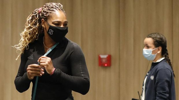 Serena Williams of the U.S., left, leaves after a press conference in which she announced her withdrawal from the tournament because of an Achilles injury prior to her second round match of the French Open tennis tournament at the Roland Garros stadium in Paris, France, Wednesday, Sept. 30, 2020. (AP Photo/Christophe Ena)