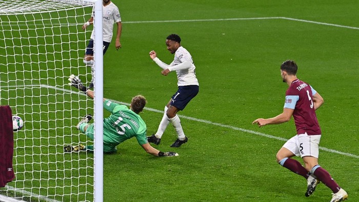 BURNLEY, ENGLAND - SEPTEMBER 30: Raheem Sterling of Manchester City scores his sides second goal during the Carabao Cup fourth round match between Burnley and Manchester City at Turf Moor on September 30, 2020 in Burnley, England. Football Stadiums around United Kingdom remain empty due to the Coronavirus Pandemic as Government social distancing laws prohibit fans inside venues resulting in fixtures being played behind closed doors. (Photo by Paul Ellis - Pool/Getty Images)