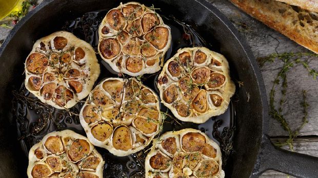 Roasted Garlic with Salt, Pepper, Thyme and Olive Oil in a Cast Iron Skillet