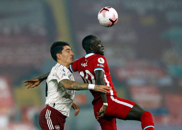 LIVERPOOL, ENGLAND - SEPTEMBER 28: Sadio Mane of Liverpool wins a header in front of Hector Bellerin of Arsenal during the Premier League match between Liverpool and Arsenal at Anfield on September 28, 2020 in Liverpool, England. Sporting stadiums around the UK remain under strict restrictions due to the Coronavirus Pandemic as Government social distancing laws prohibit fans inside venues resulting in games being played behind closed doors. (Photo by Jason Cairnduff - Pool/Getty Images)